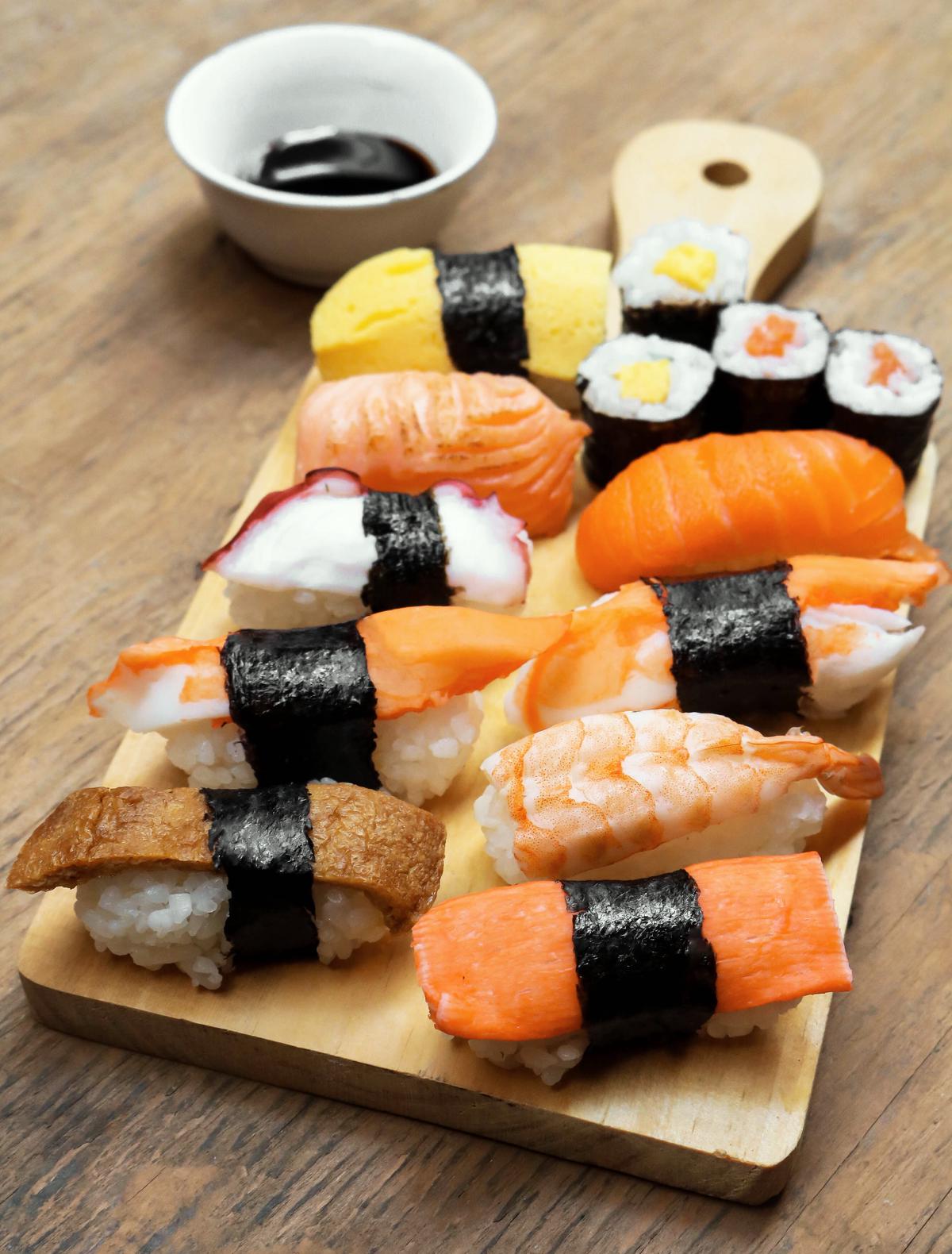 Una imagen de sushi deliciosamente preparado en un plato de madera tradicional.
